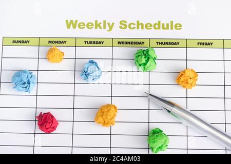 Daily schedule with pen and colorful crumpled paper balls. Close up. Stock Photo