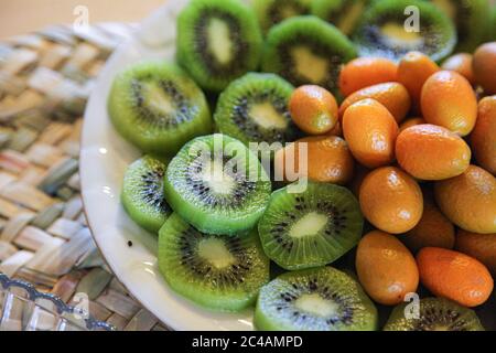 Sliced kiwi and kinkan fruits in a plate Stock Photo