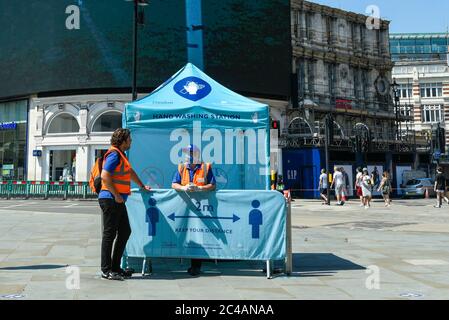 London, UK.  25 June 2020. Staff at a hand washing station in Piccadilly Circus during the coronavirus pandemic.  The initiative is sponsored by the Mayor of London and City of Westminster. Credit: Stephen Chung / Alamy Live News Stock Photo