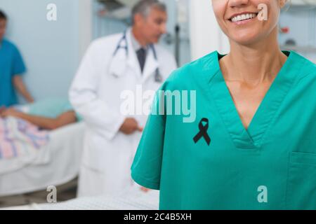 Mid section of lady nurse with black ribbon on robe smiling Stock Photo