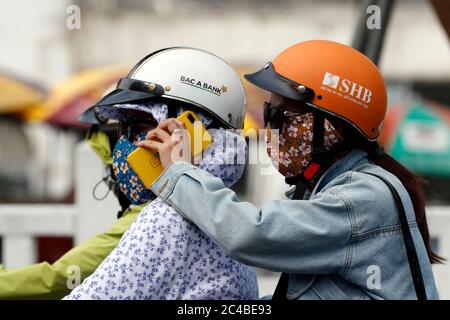 Two woman driving a motorbike and using a smartphone Stock Photo