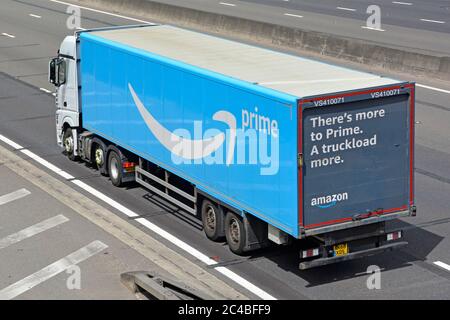 Aerial side & back view of white lorry truck blue Amazon supply chain articulated delivery trailer with advertising on rear door travel on UK motorway Stock Photo