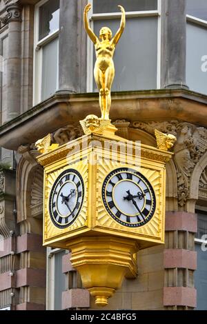 Close up Venus like golden lady statue in gold leaf above two clock face on corner of old Victorian Northern Goldsmiths store building Newcastle UK Stock Photo