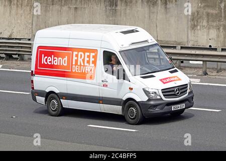 Front & side view Iceland free delivery advertising on frozen food groceries supermarket business Mercedes Benz home delivery van & driver UK motorway Stock Photo