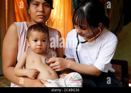 Volunteer of French NGO Chaine de l'Espoir visiting a child suffering of heart disease. Medical consultation. Buon Me Thuot. Vietnam. Stock Photo