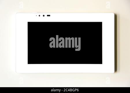 touchscreen control tablet smart home in white on a beige wall, close up of home appliances control device. Stock Photo