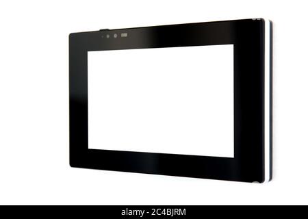 touchscreen tablet with a blank white screen and a black case mounted on a white wall to control smart home technology, close-up side view. Stock Photo