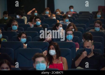 Spectators wearing face masks sit as they keep a safe distance before the movie at Albeniz cinema amid the coronavirus (COVID-19) outbreak.The Albeniz cinema has reopened its doors with a free cinema session, guaranteeing to spectator’s safety measures such as facemasks, sanitizers and social distance marks inside the cinema. Stock Photo