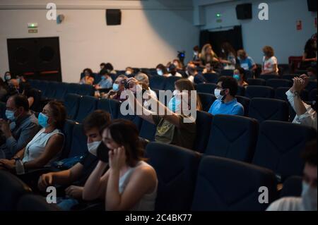 Spectators wearing face masks sit as they keep a safe distance before the movie at Albeniz cinema amid the coronavirus (COVID-19) outbreak.The Albeniz cinema has reopened its doors with a free cinema session, guaranteeing to spectator’s safety measures such as facemasks, sanitizers and social distance marks inside the cinema. Stock Photo