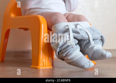 Little baby boy sitting on an orange pot Stock Photo