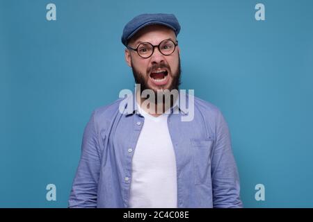 Man with grumpy grimace on his face, with mouth opened in shout Stock Photo