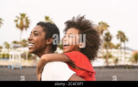 Happy African family on the beach during summer holidays - Afro American people having fun on vacation time