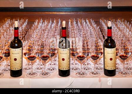 Three bottles of Masseto from Tenuta dell'Ornellaia stand among closely lined-up glasses, some filled with red wine, on a sideboard in the Hotel and Restaurant Kronenschlösschen in Hattenheim, Eltville am Rhein, Hesse, Germany. The Merlot from Bolgheri in Tuscany is regarded as one of the most famous red wines in the world. It is served on 24 February 2017 at the World Rarities Dinner (Weltraritätendinner) of the Hessian State Wineries Kloster Eberbach (Hessische Staatsweingüter Kloster Eberbach). The occasion is the 21st Rheingau Gourmet & Wein Festival. Stock Photo