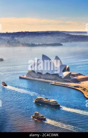 Blue waters of Sydney harbour with Ferries NSW on route to various destinations seen from altitude of Circular Quay towers.