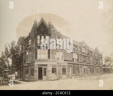 Antique c1890 photograph, small corner grocer in building in Montclair, New Jersey, likely at the corner of Forest and Walnut Streets. There is a small “Eat Quaker Oats” sign in the window, and various cans and goods are visible inside. SOURCE: ORIGINAL PHOTOGRAPH Stock Photo