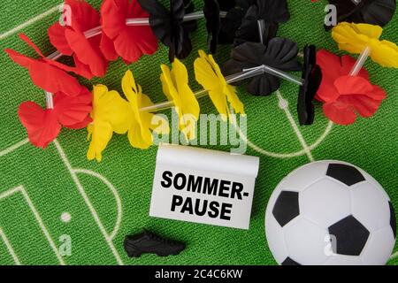 Sommerpause in german language means Summer Break. Soccer Ball with flower necklace in the colors of german flag and calendar Stock Photo