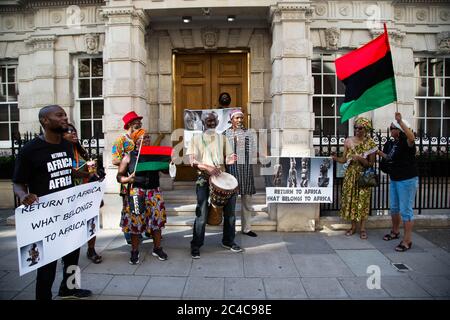 London, UK. 25th June, 2020. Protesters holding a banner and flags during the demonstration.Protesters from the ‘Africans in the Diaspora' gather outside Christie's to demand the return of African Artifacts. Europe's museums are fighting to keep Africa's artifacts as pressure mounts from campaigners. Credit: SOPA Images Limited/Alamy Live News Stock Photo