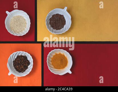 Spices and grains in white cups on colorful napkins Stock Photo