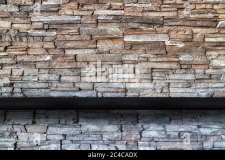 Stone brick wall background with empty black wooded shelf  for mock up display or montage of product design and copy space. Stock Photo