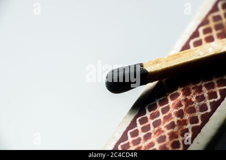 Isolated match stick kept over the edge of a matchbox in a white background. Space for text in left Stock Photo