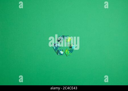 Recycling icon made from paper colored with paint in a green background. Stock Photo