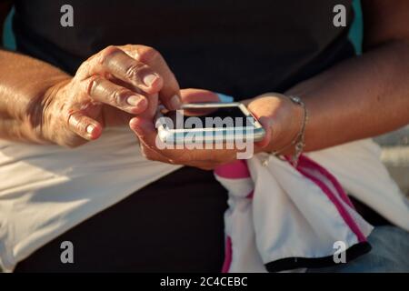 Midsection of senior woman using mobile phone Stock Photo