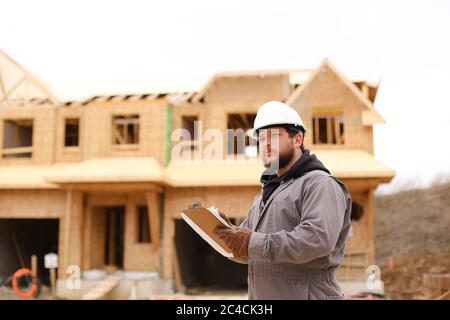 Engineer drawing plan in notebook at construction site. Stock Photo