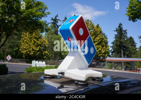 The Domino's Pizza sign is seen atop a pizza delivery car outside