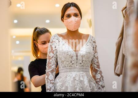 Face coverings are worn by bride to be Jessica Letheren and bridal consultant Felicity Gray during a dress fitting appointment at Allison Jayne Bridalwear in Clifton, Bristol, which has reopened following the lifting of coronavirus lockdown restrictions, with measures put in place to prevent the spread of coronavirus during brides' dress fittings. Stock Photo