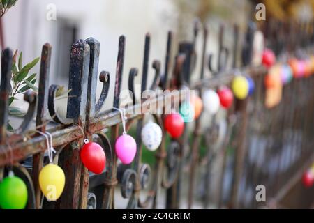 Colorfully colored Easter eggs hang in a row on an old garden fence, Bremen, Germany Stock Photo