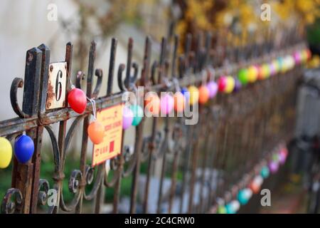 Colorfully colored Easter eggs hang in a row on an old garden fence, Bremen, Germany Stock Photo
