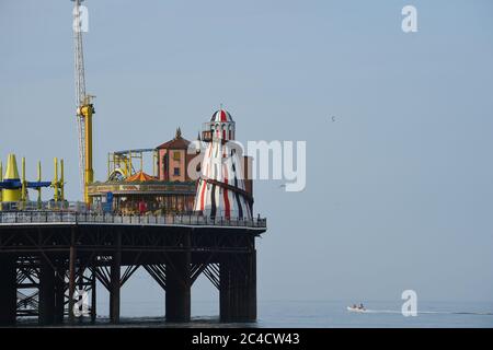 Brighton UK 26th June 2020 - A speed boat passes by the Brighton Palace Pier early this morning on another beautiful hot sunny day . Crowds flocked to Brighton yesterday which was the hottest day of the year so far  : Credit Simon Dack / Alamy Live News Stock Photo