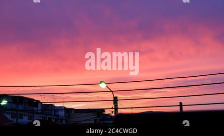 Silhouette of Street lamp illuminating and the clouds  Background  Golden light of sunset in the evening on the sky. Stock Photo
