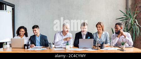 Happy Coworkers Working Together Discussing Project Sitting In Office, Panorama Stock Photo
