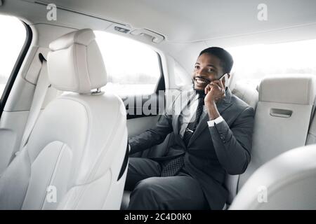 Businessman Talking On Phone Sitting In Car During Business Trip Stock Photo
