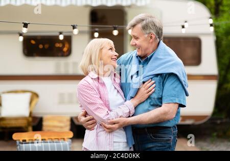 Beautiful elderly couple hugging each other during camper vacation outdoor Stock Photo