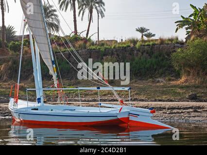Traditional egyptian felluca sailing boat on river Nile with reflection Stock Photo