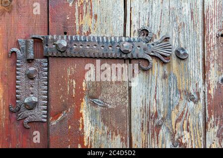 Old rusty door hinge on wooden planks, decoration detail Stock Photo