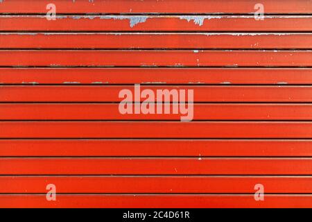 Orange metal shutter texture. Architectural detail, closeup. Material background. Paint peeling and ruined by time and bad weather. Stock Photo