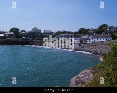 View across bay to pebbly beach of this small popular fishing village Moelfre Isle of Anglesey North Wales UK at high tide Stock Photo