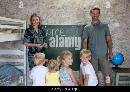 Portrait of a big family at the blackboard at home school. Stock Photo