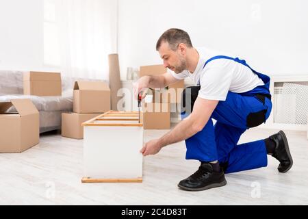 Repair Worker Installing Shelf Using Screwdriver Working Indoors Stock Photo