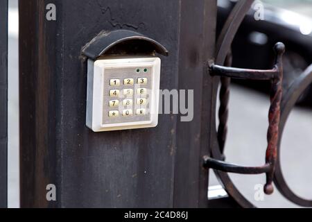 electronic security lock for access with buttons for entering the installed password on the iron forged gate, close up pin input buttons. Stock Photo