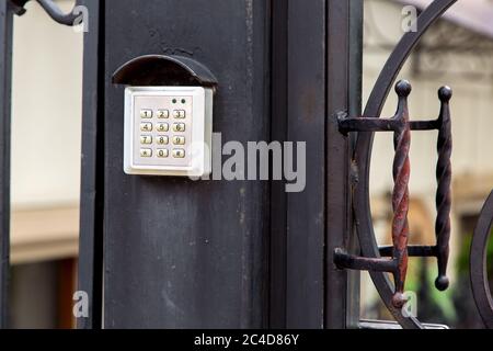 electronic security lock for access with buttons for entering the installed password on the iron forged gate with handle, close up. Stock Photo