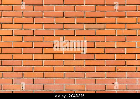 texture of an orange brick wall, building facade is made of facing brick. Stock Photo