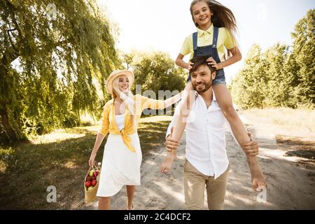 Family Walking Spending Time Together Going On Picnic In Countryside Stock Photo