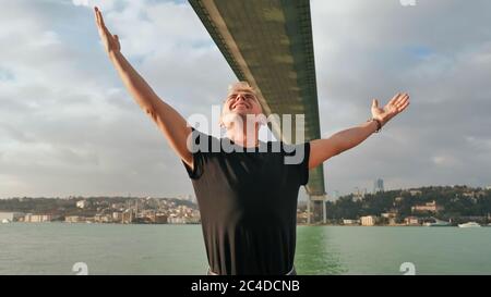 A young man admires the huge bridge over the Bosphorus in Istanbul. Turkey. Stock Photo