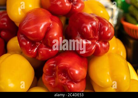 Pile of colorful peppers on market place near the green Stock Photo