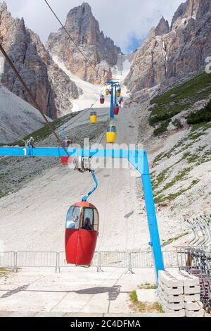 Colorful cable car leading to Forcella Staunies with two young girl passangers, in the Mount Cristallo massif (Cortina d'Ampezzo, Dolomites, Italy Stock Photo