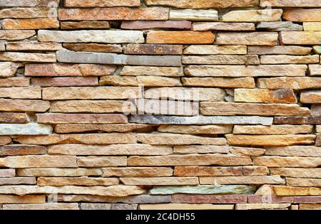 The texture and background of the stone wall are made of pieces of old flat gold sandstone in light blur. Stock Photo